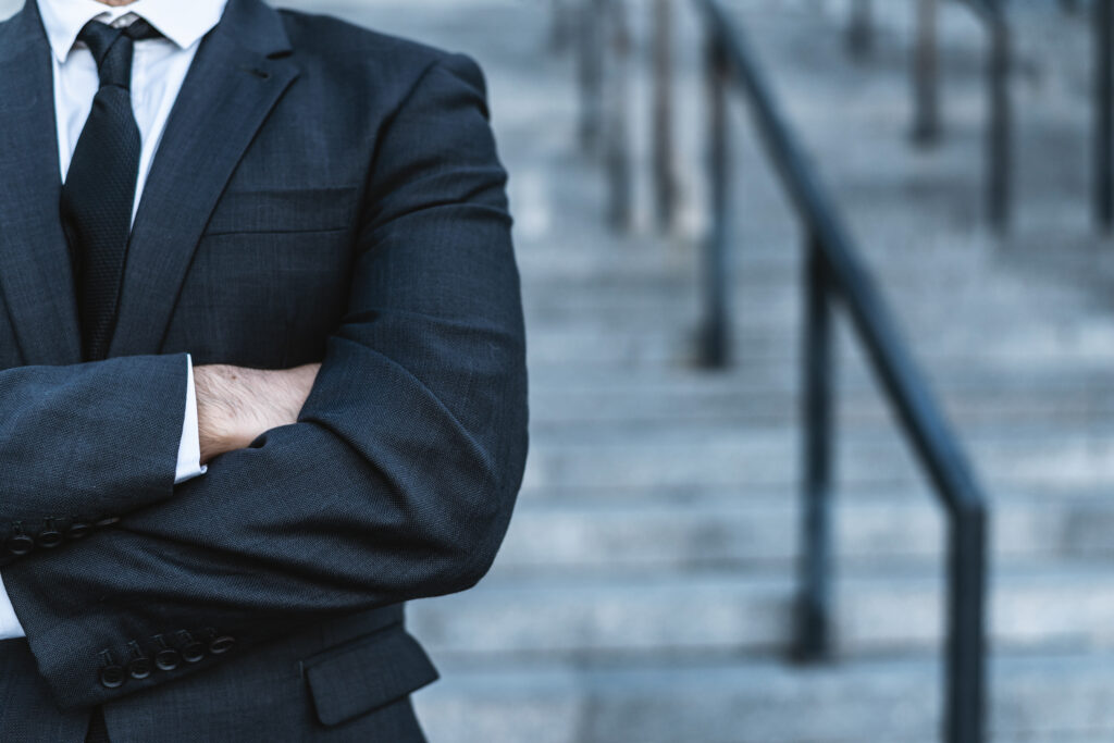 Close-up businessman crossing his hands posing against the back