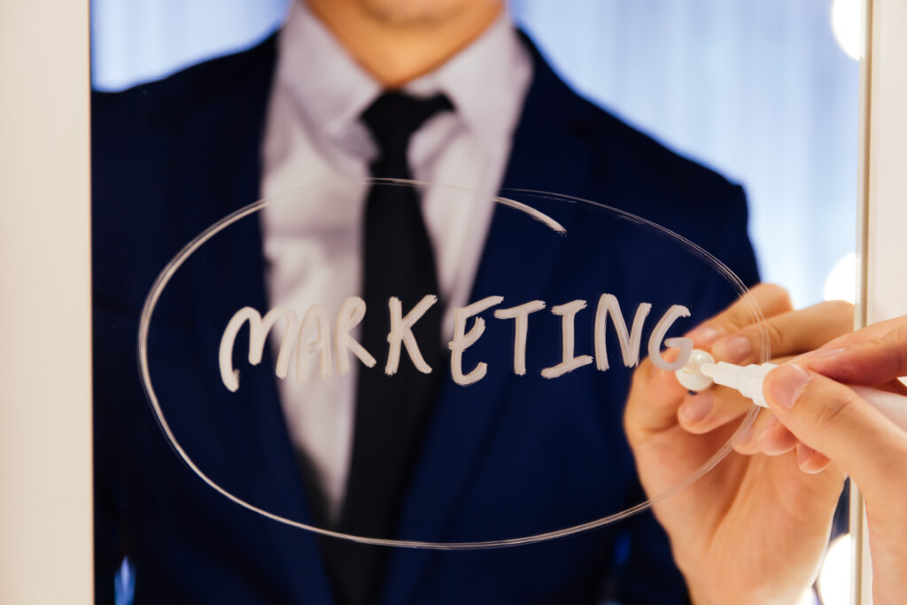 Smart business man writing the word Marketing on the mirror board - Business marketing and branding strategy reminder