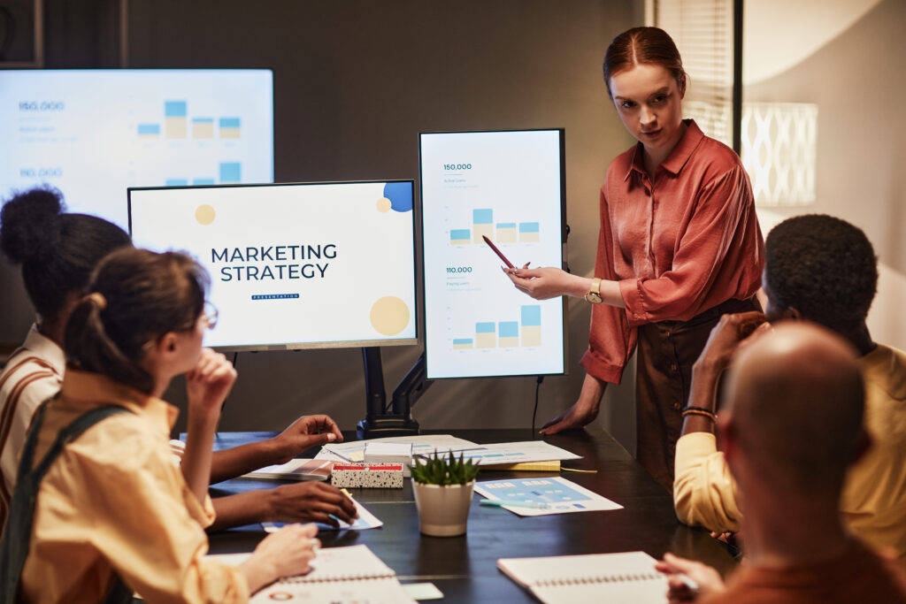 Young Businesswoman Explaining Strategy To Team, online masters degree in marketing