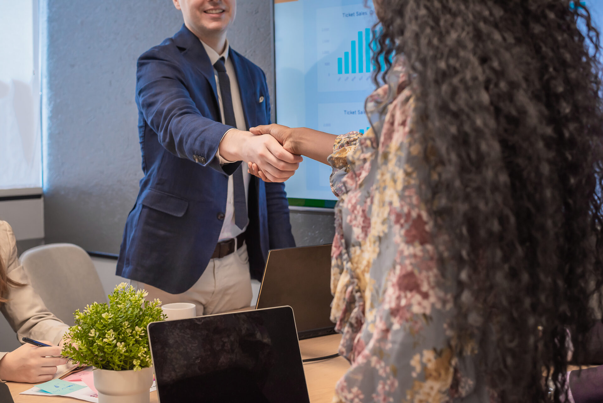 Business man shake hands with business women agreeing on partnerships or introducing themselves for first time meet.