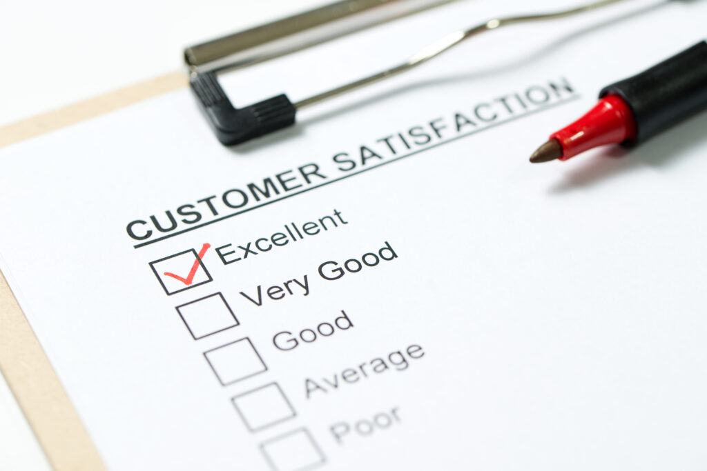 Customer satisfaction survey form on clipboard with red pen