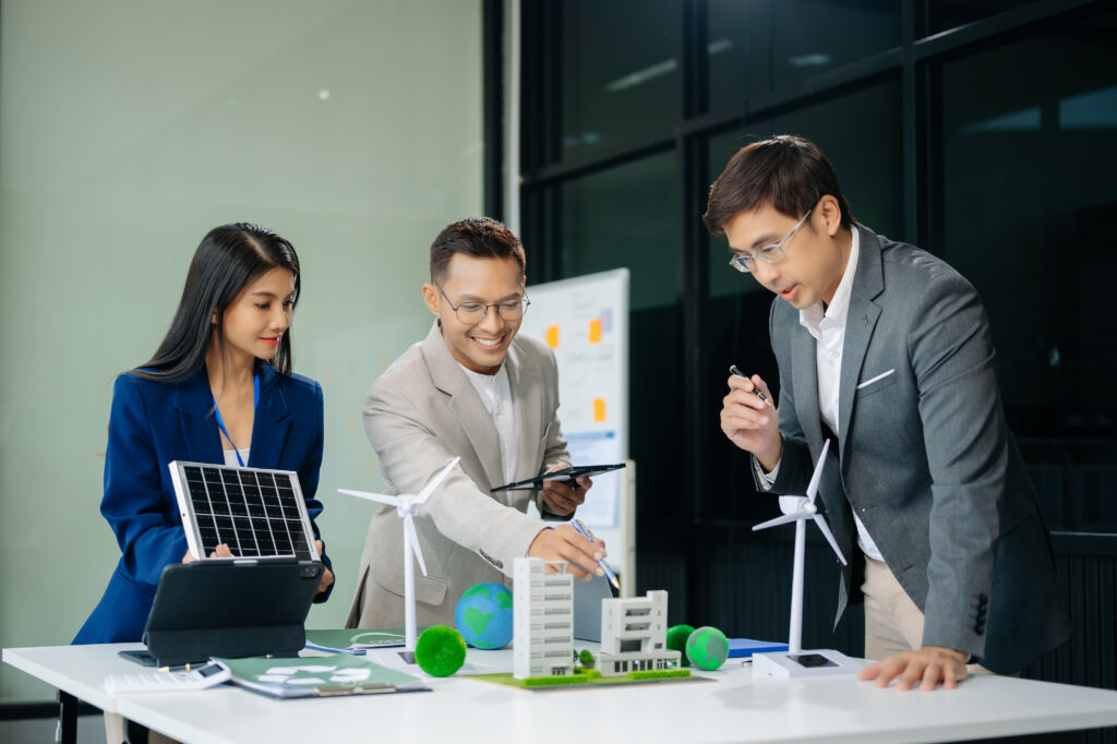 Group of businesspeople standing neare table looking at model of